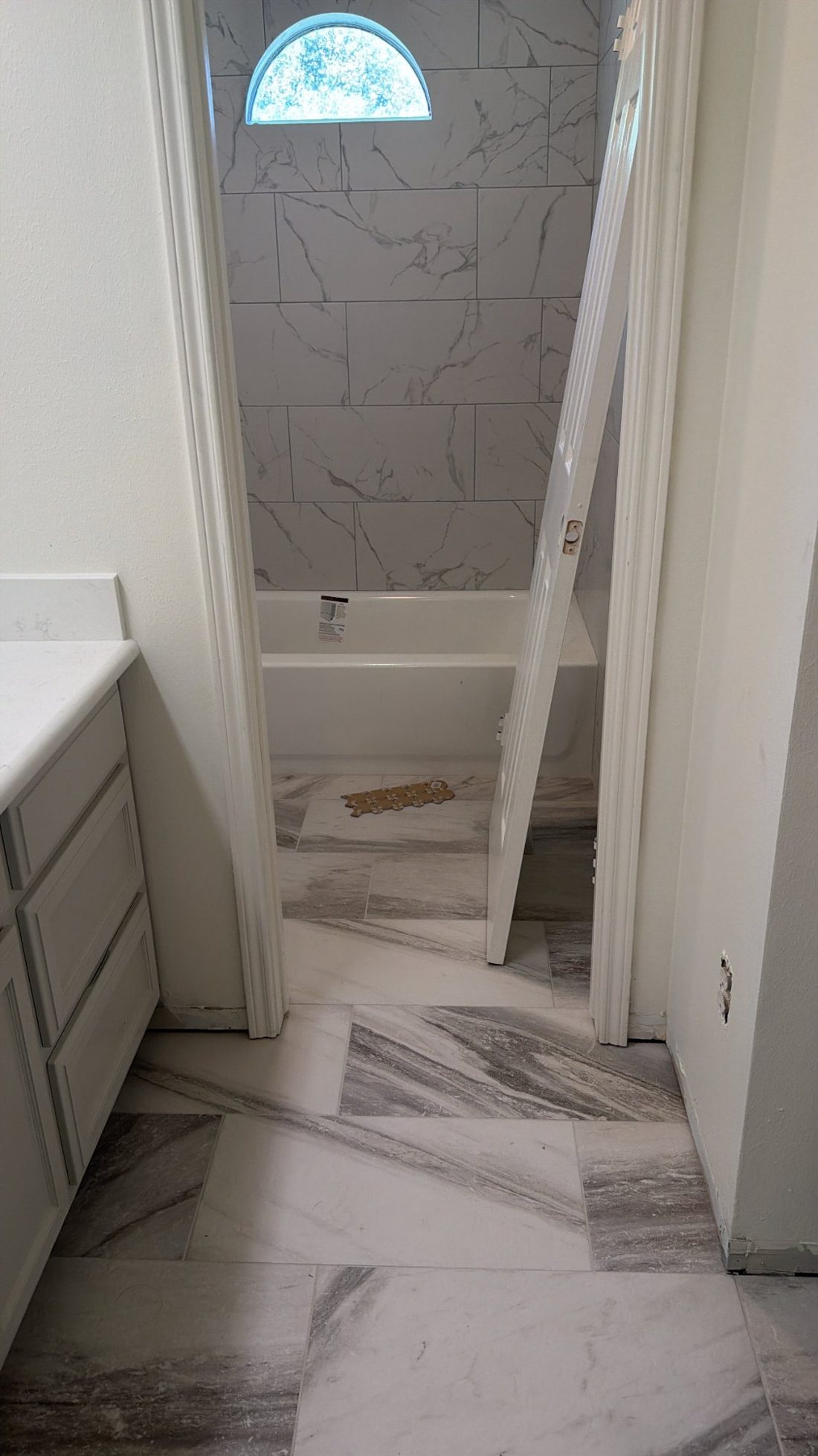Finished bathroom remodel with marble floor and new vanity
