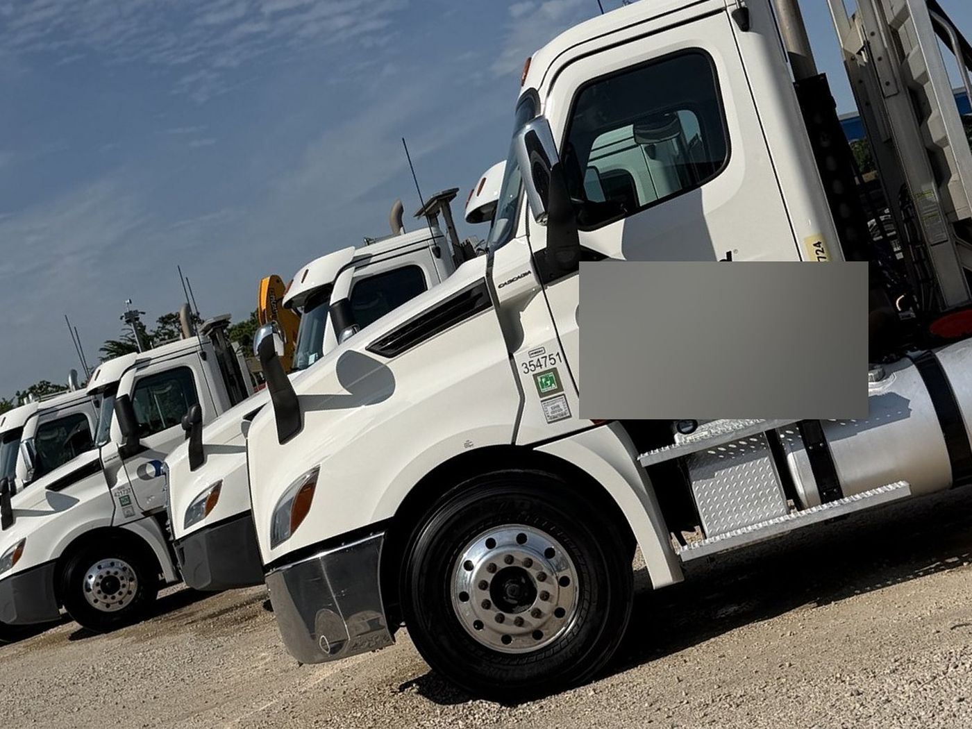 Line of commercial fleet trucks detailed and staged at the yard