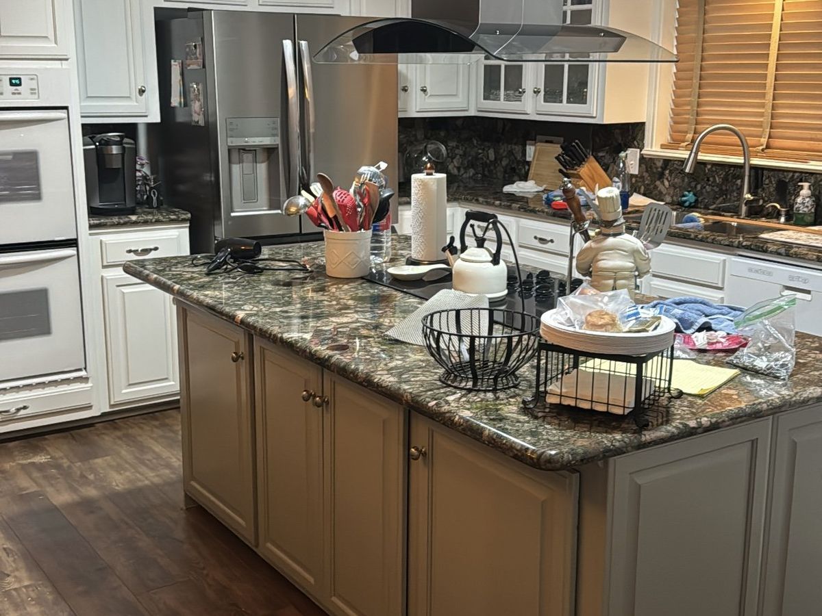 Finished kitchen with granite island and vent hood